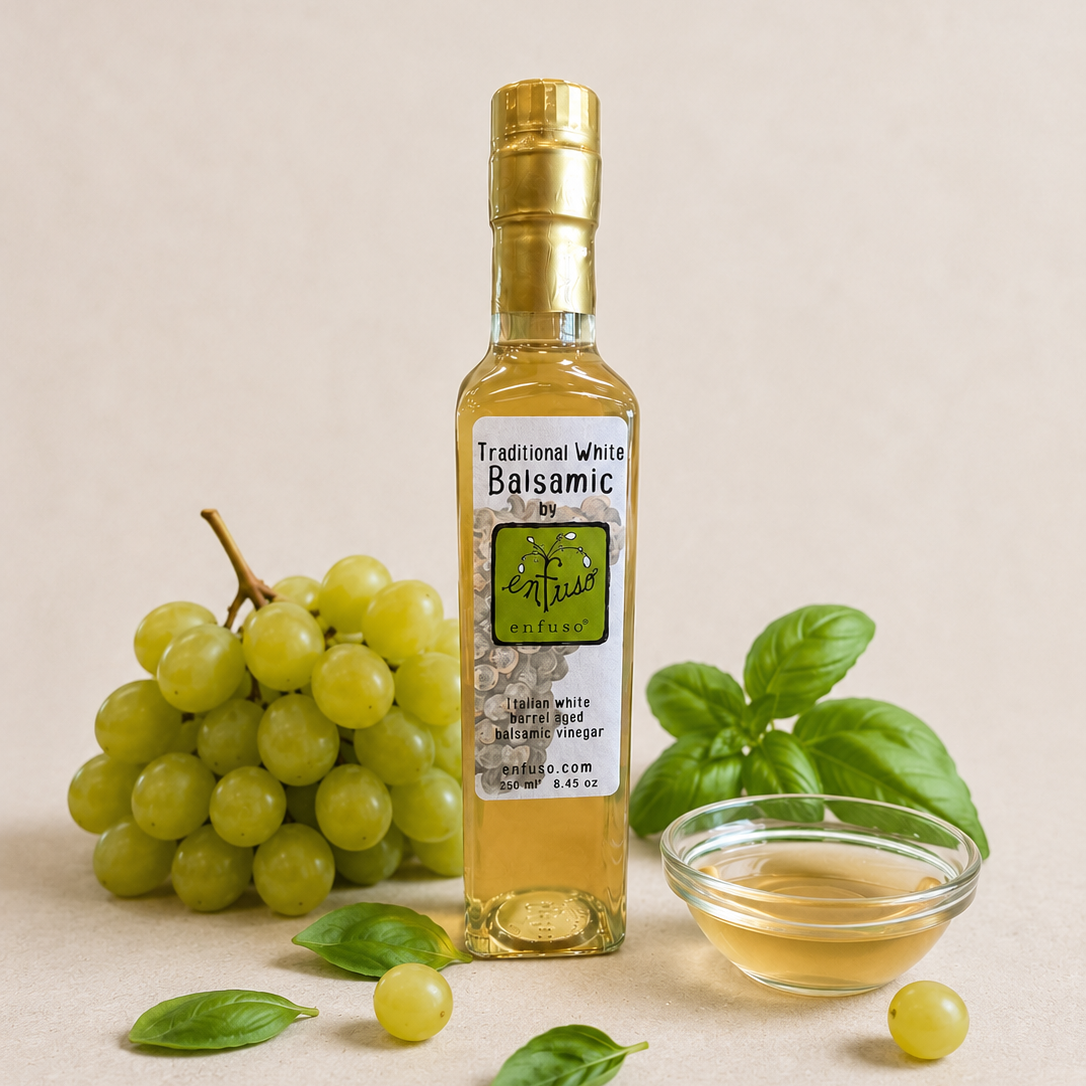 Bottle of balsamic vinegar with grapes and basil on a beige background