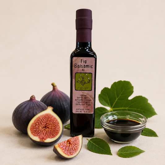 Bottle of Fig Balsamic Vinegar with fresh figs and leaves on a beige background