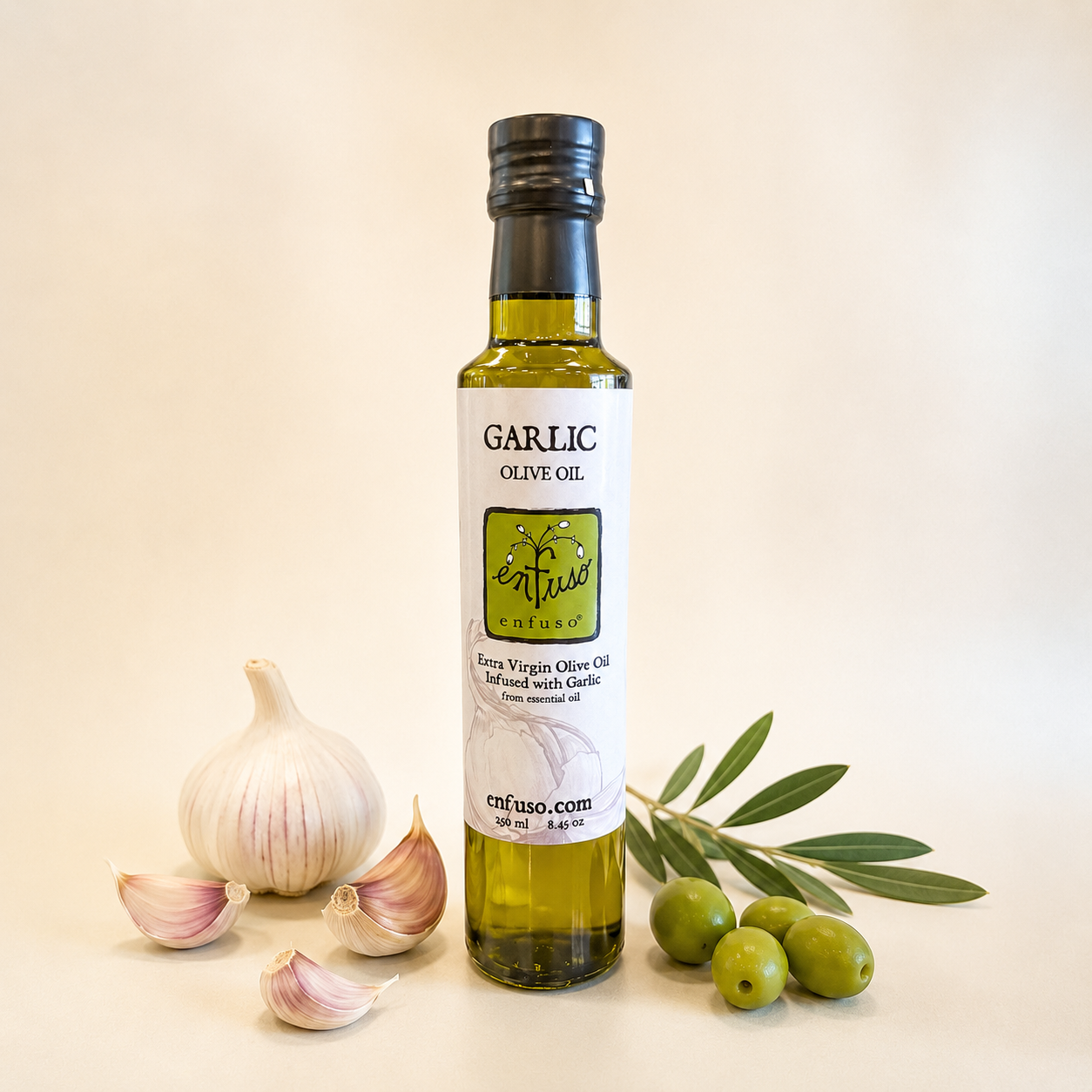 Bottle of garlic olive oil with garlic bulbs and olives on a beige background