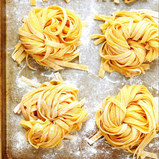 Piles of uncooked pasta on a baking sheet